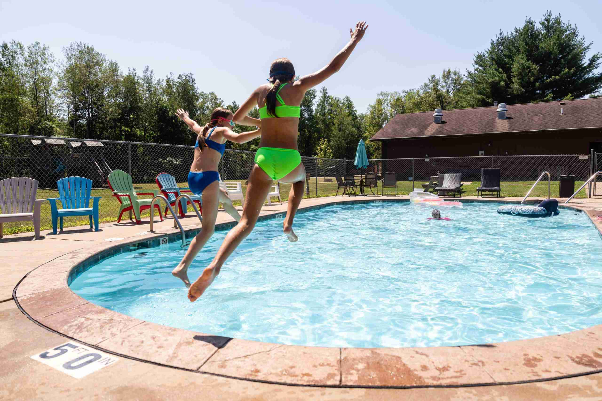 Kids jumping into the heated pool at Heaven’s Up North Campground