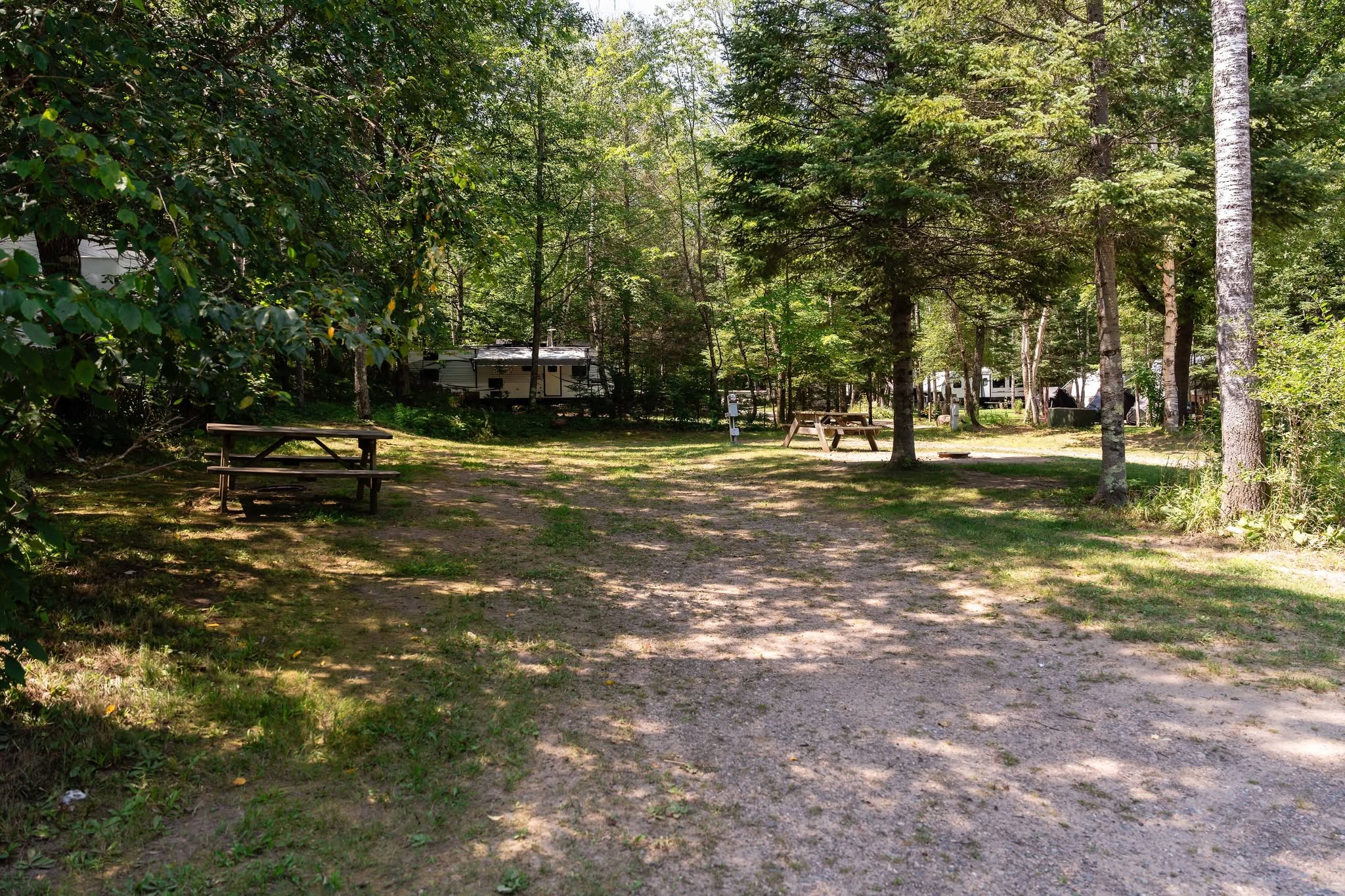 A wooded RV site at Heaven’s Up North Campground