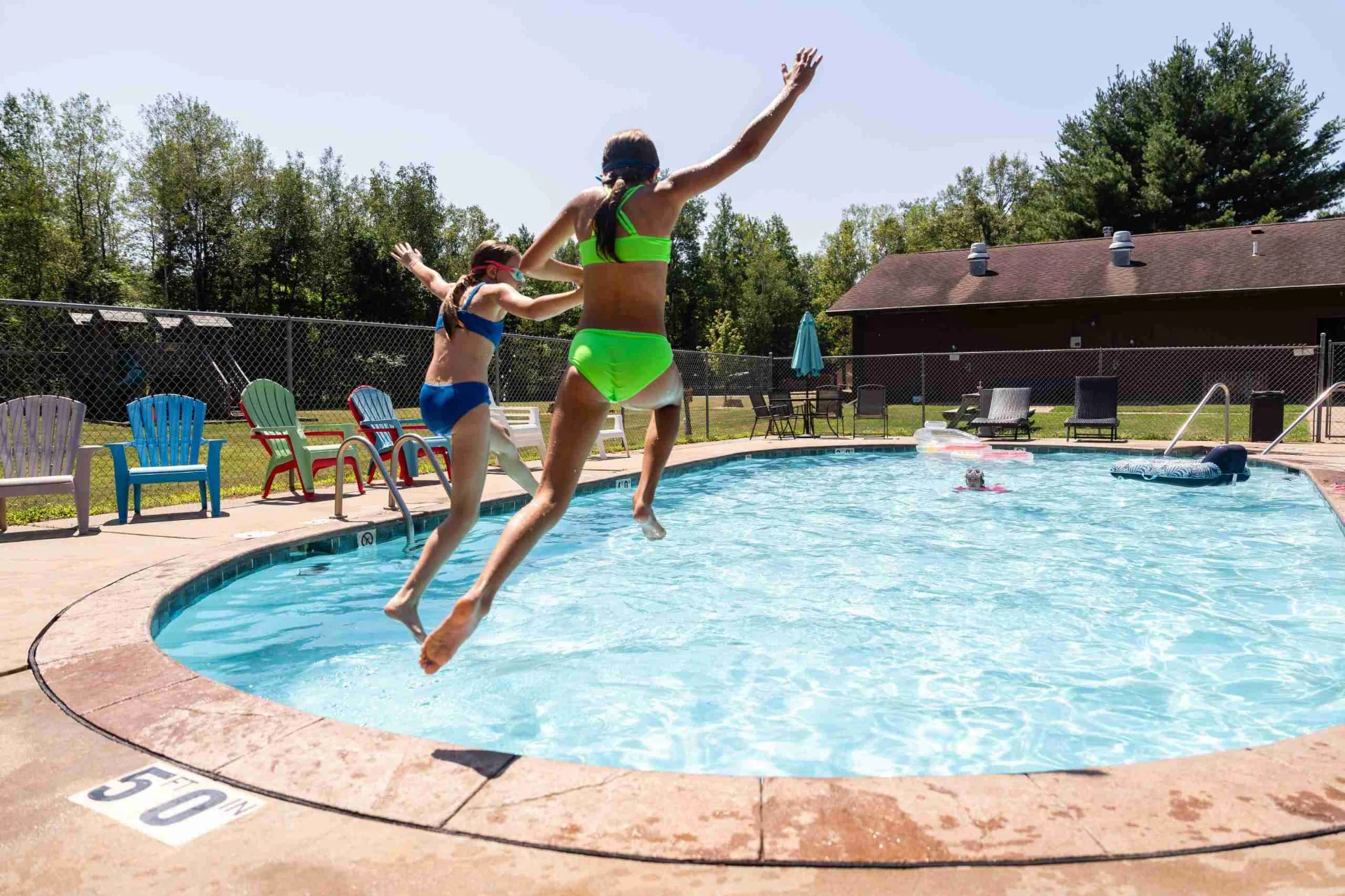 Kids jumping into the heated pool at Heaven’s Up North Campground